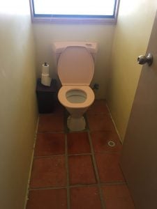 Old toilet on tiled floor